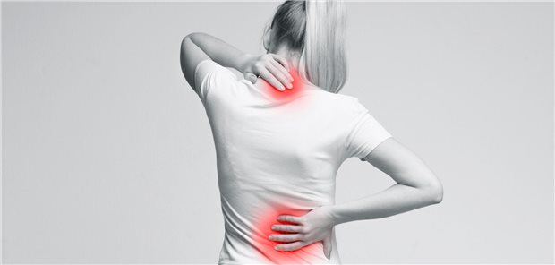 Chronische Rückenschmerzen: Spritzen an der Wirbelsäule wohl nahezu wirkungslos Eine Frau in Rückansicht fasst sich mit der linken Hand an den Nacken, mit der rechten Hand an die untere Wirbelsäule.