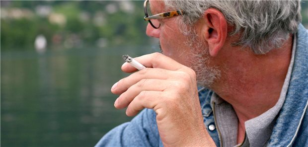 Raucherentwöhnung älterer Erwachsener mit verlangsamtem kognitiven Abbau verbunden Ein ältere Mann in seinen 60ern raucht eine Zigarette. Sein Gesicht ist von der Kamera weggedreht.
