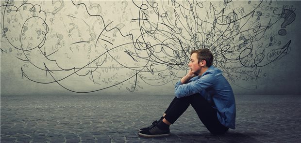 Weniger Suizidverhalten und Substanzmissbrauch unter ADHS-Medikation Ein junger Mann sitzt nachdenktich auf den Boden.