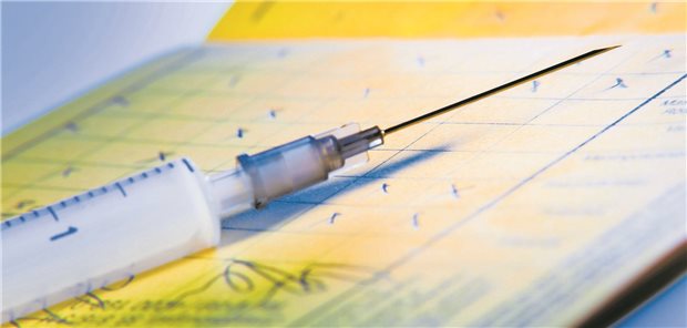 Reisezeit, Impfzeit! Das sind die STIKO-Neuerungen zu Reiseimpfungen Eine Spritze liegt auf einem Impfpass.