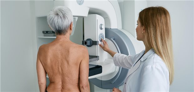 Eine grauhaarige Frau bekommt eine Mammografie.