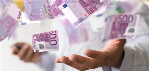 Eine Hand fängt 500-Euro-Geldscheine auf, die durch die Luft wirbeln.