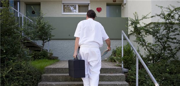 Bei 23 Millionen Praxis-Hausbesuchen: Zi hält zusätzlichen aufsuchenden Dienst für unnötig Arzt mit Koffer geht Treppen zu einem Haus hoch.