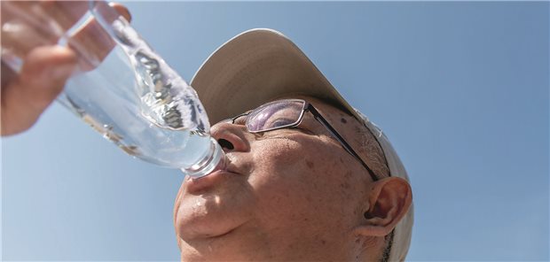 Ein älterer Herr trinkt aus einer Wasserflasche.