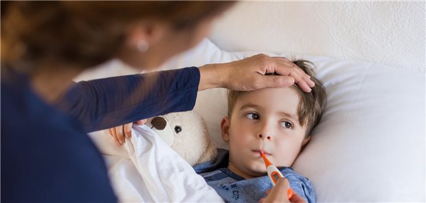 Eine Mutter misst die Temperatur ihres kranken Sohnes, durch ein Thermometer in seinem Mund.