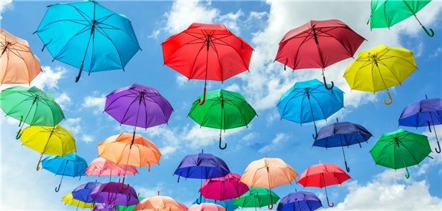 In Finnland leben die glücklichsten Menschen Bunte Regenschirme am Himmel