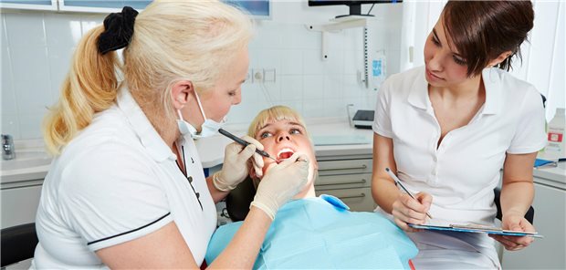 ZFA in der Praxis, während eine Ärztin eine Patientin untersucht.