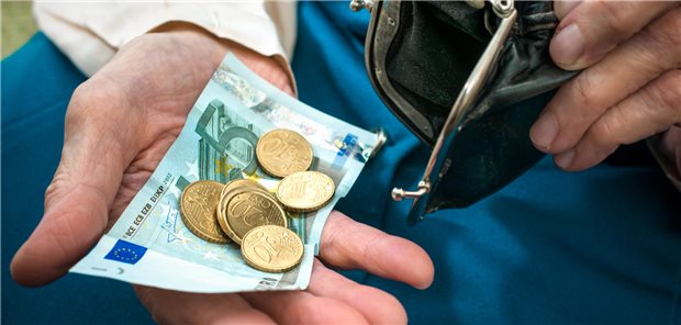 Ein Mann hält Geldmünzen in seiner Hand.